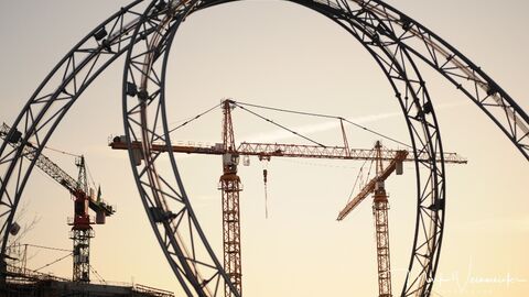 Großbaustelle Baukräne hinter Achterbahnschienen