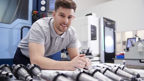 Männlicher Ingenieur mit CAD-Plänen in einem Werk