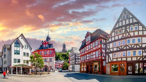 Fachwerkhäuser in gepflegter Innenstadt unter farbengetränktem Himmel